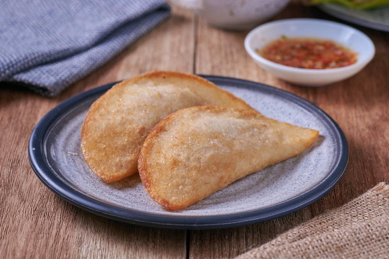 Empanadas fritas doradas acompañadas de ají de la casa en La Doña Hacienda