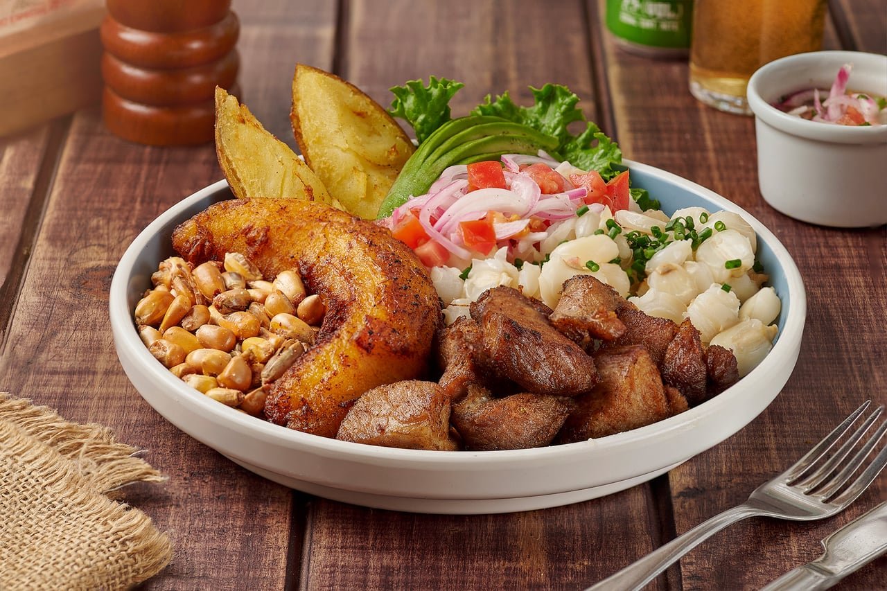 Plato tradicional con carnes, mote, aguacate y curtido, servido en La Doña Hacienda